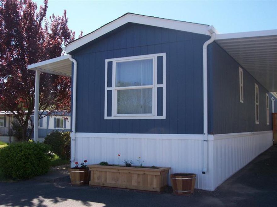 Comfortable & Affordable Living in a 55+ Park! This single-wide manufactured home is currently being remodeled. When it is finished it's going to be a BEAUTY! The all-electric home features 2 bedrooms (one at each end), 2 bathrooms, a large living room under vaulted ceilings, a convenient kitchen with a breakfast bar on each side & room for a dining area in either the kitchen or living room. The kitchen has lots of cabinets, a range/oven, a refrigerator & double sink under a window. Down the hall is a place for both a washer & dryer. The home is very clean with almost new carpet & vinyl & all window coverings go with the home. Located on a corner lot, there are beautiful views from every window of mountains & countryside. Outside there is a new deck at the front door, a new carport & a new storage shed. The park has been beautified recently & the space rent is low & affordable. Come see for yourself. You may want to stay!
