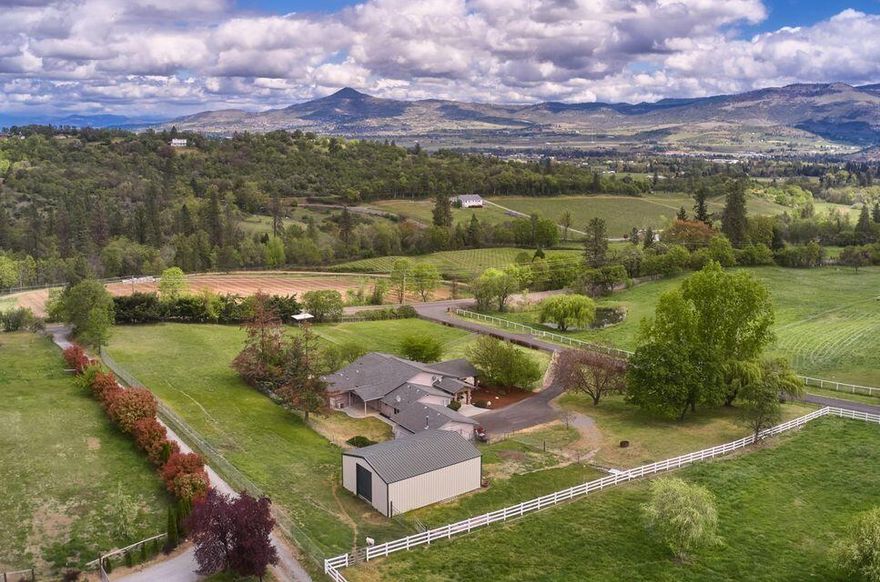 Welcome to this beautiful oasis located just outside of the city limits of Medford. As you drive up to the home you will notice the home has a paved driveway and iron fencing. With having irrigation rights the property has a lushes green look to it. Walking into the home you are blown away with an oversize great room with tile that flows throughout the home. The ceiling height provides that grand look and is finished with beautiful crown molding. This single-level home that offers a split floor plan has 4 bedrooms and 3 bathrooms. Two of the rooms have an en-suite bathroom. The main master suite is an oversized room with a walk-in closet and a huge bathroom. The kitchen has stainless steel appliances. The home also offers central vac, radiant heat for the tile during those cold winter nights, a movie theater that has been professionally wired by Scott Jones at the Music Shop. The property is just under 3 acres that are completely fenced and have a detached barn with stalls.