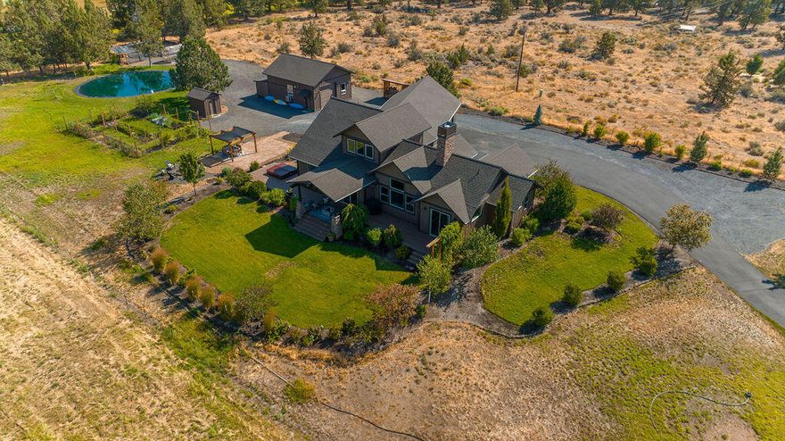 Inspiring country setting just minutes from downtown Bend. Classic NW home offers exceptional, SINGLE LEVEL LIVING on 4.86 ac w/stunning Cascade views. Beautiful design elements include timber beam, stone, and warm wood throughout. Natural light-filled Great Room, features wood burning fp, soaring ceilings, and windows framing the Cascades. Chef's kitchen w/granite slab counters, island, and stainless appl. Main level Primary Suite features access to the back deck, spa-like ba w/granite vanity, tiled shower, and walk-in closet. 2 add'l bd w/Jack-and-Jill bath. Upstairs features large 4th en suite/bonus room. Large 3-car garage. Multiple outdoor spaces, including expansive deck and dining gazebo, firepit, and hot tub deck. Beautifully landscaped yard, and vegetable/flower garden with deer fencing. Detached 3-car garage/shop with loft. Chicken coop. Horse/livestock ready, fully fenced 3.86ac pasture complete with electric fencing, loafing shed, COIC pond irrigation.