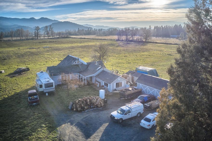 Well-priced opportunity on 78.79 level and fully fenced acres of prime Exclusive Farm land. Property is situated in the picturesque Illinois Valley near wineries and vineyards.  Measures have been taken to ensure an abundance of water is  readily available. In addition to irrigation rights, seller has recently installed a million-gallon irrigation pond.  Possibility for multiple income streams with a primary ranch-style home, a 1977 manufactured home near the pond and a 3440 sq/ft enclosed barn with loft and multiple outbuildings. Primary home has plenty of peaceful living space and is ready for your finishing touches. This property is primed and ready for a new owner/investor. Call for details.