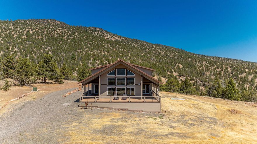 NEW PRICE & Motivated Seller! Privately situated on Grizzly Mountain, just minutes from Downtown Prineville, this 65 ACRE retreat offers a stunning, peaceful setting, modern rustic charm, & sweeping Cascade Mountain views. Built in 2019, the 4BR/3BA home offers an open kitchen w/dramatic wood slab island, stainless appl, solid surface countertops and walk-in pantry. Exquisite Great Rm filled with natural light, features a wall of windows framing the panoramic views, floor-to-ceiling stone fireplace, warm wood accents and soaring ceilings. 2 Main Level en suite bedrooms. Upstairs: Spacious Bonus/Game Rm and 2 additional bedrooms. 1,141 SF 3+ car garage. Property boarders 785 acres of BLM land creating more privacy than you could ever imagine. Three 2,500-gallon cisterns, 500-gallon propane tank, 1,000-gallon septic, and ideal solar slope. RV hook-ups. Land Owner Preference (LOP) hunting tags available. STR eligible. Experience star-filled skies and awe-inspiring sunsets from this high-desert escape.