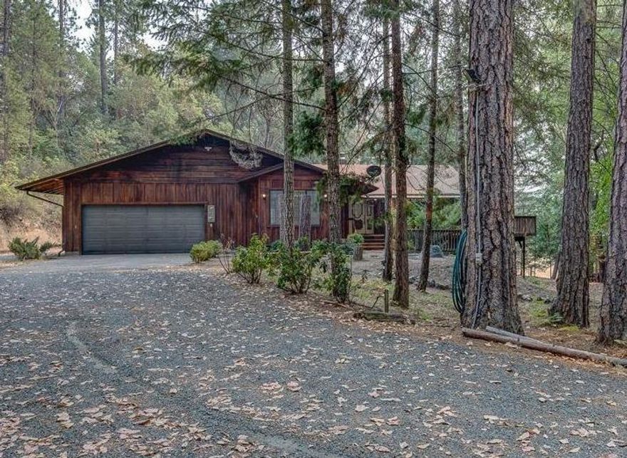 Come live the Oregon dream on this private and peaceful 5.12 acre forested property in Rogue River. The home is light and bright with lots of windows and many skylights. The main floor features a formal living area, 4 bedrooms, 2 full baths, the 4th bedroom has built in cabinets and a desk that would also make for a good home office. The open kitchen has oak cabinetry with stainless steel appliances and opens to a living room area with a wood burning stove to keep you warm on cold winter nights. The kitchen and living room open up to the large wood deck that wraps around 3/4 of the house, showcased by a large screened in outdoor room off the kitchen for enjoying your meals outside under a ceiling fan to keep you cooled off on warm summer nights, the raised deck will make you feel like you are floating in the trees. Relax in the spa just off of the back deck. The finished basement is carpeted and currently used as game room. The outside features walking trails and covered parking.