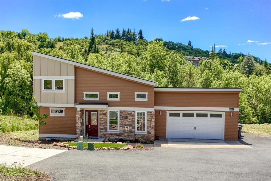 A modern masterpiece on a rare .53 acre lot in East Medford! This architecturally designed 3 bedroom, 2.5 bathroom home will wow you with all it has to offer. The great room features vaulted ceilings with clerestory windows, gorgeous hardwood floors, architectural detail, and a gas fireplace. Chefs will love the open kitchen with quartz countertops, stainless steel appliances, gas range, double ovens, and plenty of storage. The main-level master suite includes an incredible walk in closet and spacious bathroom with double sinks. Upstairs, you'll find two additional bedrooms, a full bathroom, and large bonus room. Relax on the deck outside and enjoy the privacy and views, or explore the creek running through the bottom of the property. This contemporary home offers a unique combination of modern, high-end amenities in a serene setting.