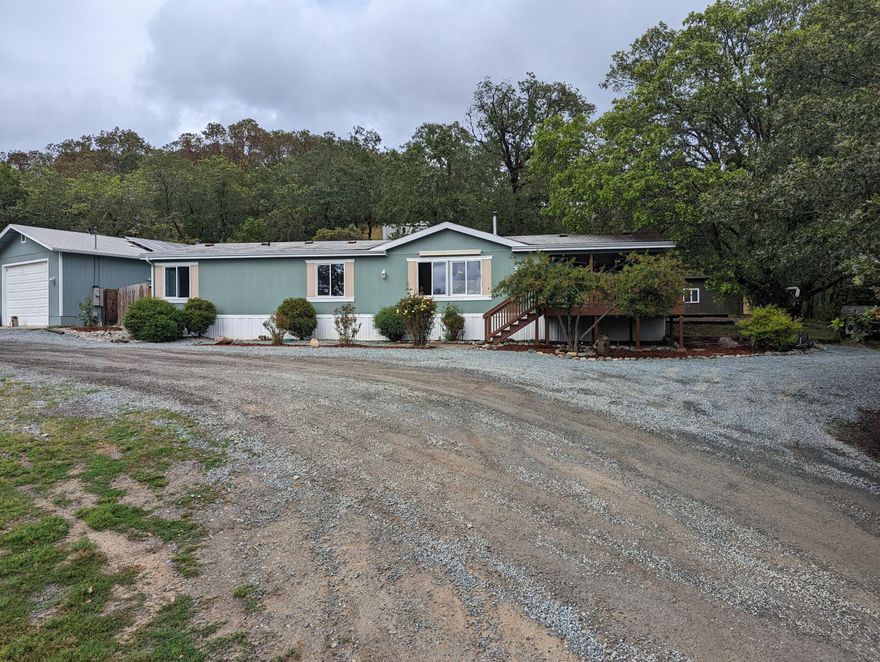 End of the road privacy on 4.31 acres in the area of Merlin. This property has it all 24 x 40 shop/garage, in ground pool, hot tub/spa and accessory building (possibly ADU), chicken coop, room for gardens and even a partially fenced pasture for critters.  This 1999 manufactured home has been totally remodeled and has hardwood floors in livng room kitchen and hall and matching laminate floors in all the bedrooms.  The countertops in the kitchen are really beautiful stone coat epoxy marble. The property has two holding tanks for water and solar panels on the roof of the shop.  Quiet private but close to town. Buyers  to do due diligence as to the uses and condition of this property.  No commissions will be paid on seller paid closing costs or prepaids. One of the sellers is related to the listing agents. The property is being cleared and containers will be gone soon.