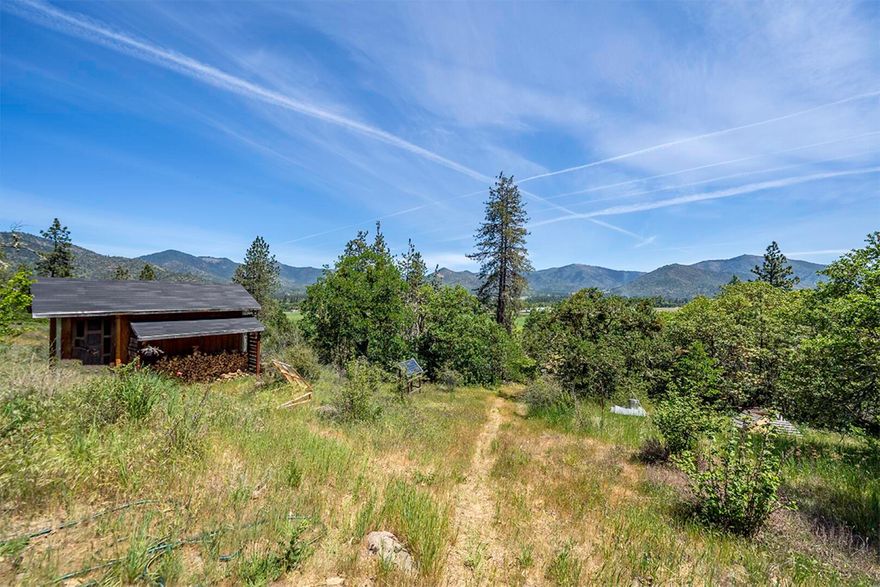 It's not often you find land with this many improvements, and at a great price. Building permit approved and on file for a 1500 sq ft house by Tom Tobey with plans. Well is in place plus a 1500 gallon water holding tank. Drip irrigation to the garden and orchard where you'll find established almonds, cherries, nectarines, hibiscus, hazelnuts, apples, blueberries, mulberry, plums, and more. There is an 8x16 permitted shed on the property plus a permitted and installed 4.65 kilowatt solar panel system, including Outback inverter with remote monitoring possibilities and eight 6-volt deep cycle batteries. Gorgeous views and great sun exposure all day long. This property is ready for you to build your home and utilize your green thumb with a small greenhouse and 16 OMMP holes. Converted bus included in sale. Agent must be present for all showings.