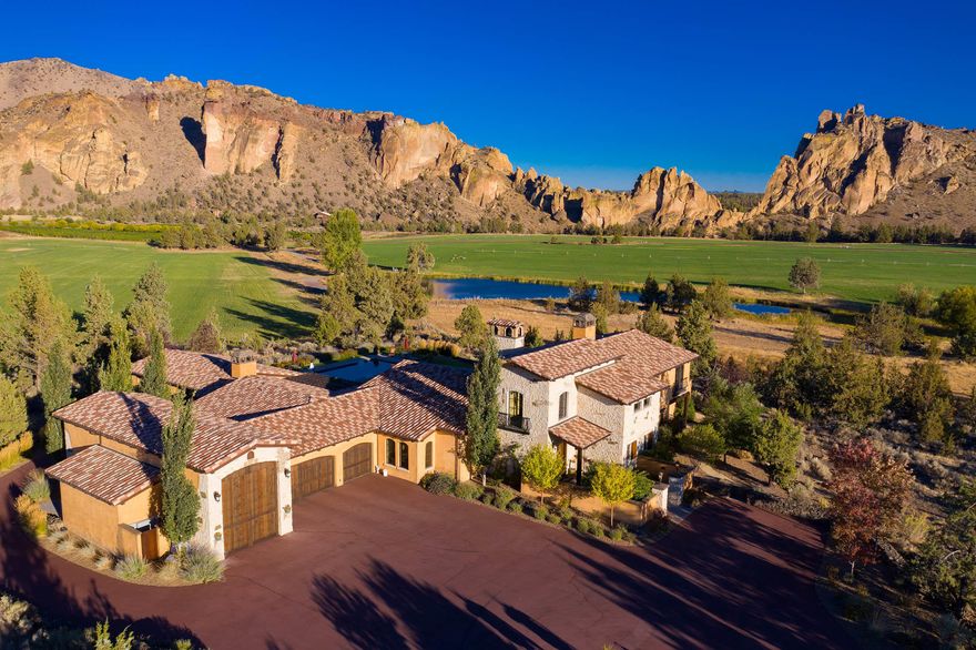 Representing a blend of sophistication, elegance and comfort, this Tuscan inspired villa is one of the most prestigious estates located in Central Oregon. Unparalleled in its sumptuous accommodations, use of fine materials and execution of exceptional detail.  Immediately become overwhelmed by a sense of style and beauty from the rough-hewn wood door, towering rock entry, winding staircase with wrought iron railing leading to the large scale formal living room and Kitchen. Designed for fun and entertaining, this ultimate private oasis was strategically positioned to offer maximum privacy, capture the commanding views of pastoral acres, vineyard, Cascade Mountains and Smith Rock.  Featuring ultimate flexibility for family, guests and work-from-home schedules there are multiple outdoor terraces, office, guest suite with separate entrance, pool house and pool.  This Legacy home is truly a one-of-a-kind gated Estate that is the perfect retreat in today's world.