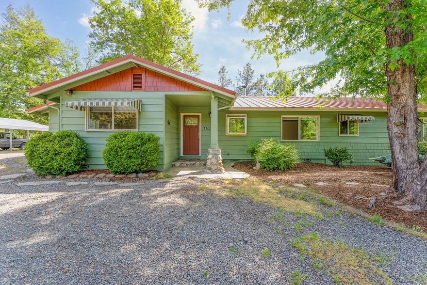 Adorable Craftsman Country home on 5 acres! Double gated and sits on a flag lot for great privacy. The home has so much charm with wood flooring, large picture windows and woodstove in living room for those cozy mornings. It also offers a split bedroom floorplan, updated guest bath and new paint. The primary bedroom is a great size with its own private patio, new  carpet, walk-in closet and the most beautiful natural light. New exterior paint, metal roof and flagstone  patios allow this home to be extremely low maintenance. Outside you will find a circle driveway, several fruit trees, organic garden, carport, RV parking + hookups. The land is flat and usable, nicely treed and plenty of space for a shop. Great producing well! You don't want to miss this country cutie! Take a look today.