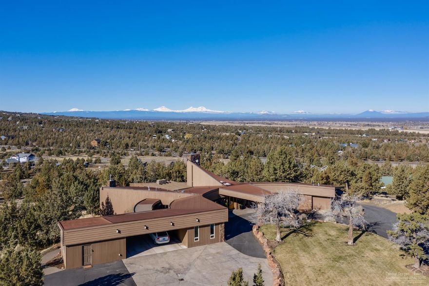 Beautiful one-of-a-kind home in Frank Lloyd Wright Style perched atop nearly 10 acres in Powell Butte! This amazing home has a soaring great room with panoramic views of all the Cascades and Smith Rock! With over 4,800 square feet of space you will have plenty of room for your family and friends to enjoy this spectacular home. In-ground saltwater heated swimming pool surrounded by huge outdoor living space. Property also has a 2400 square foot shop with electricity. Homes like this don't come along very often! This home is a must-see!