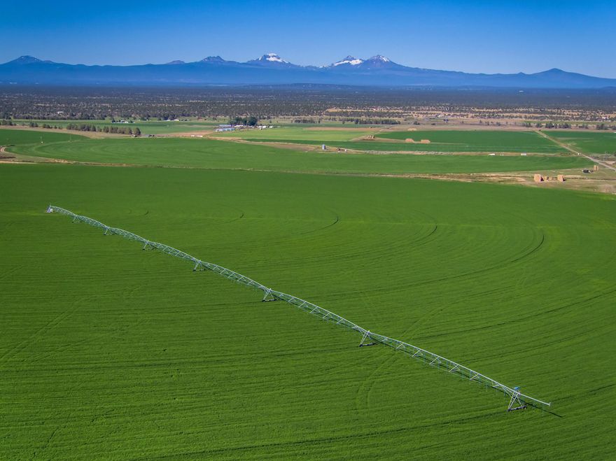 Powell Butte Farm with stunning Cascade Mountain Views in the heart of Central Oregon. This hay farm is 990 acres with 854 acres of COID water rights. Farm includes: 7 pivots, wheel lines, solid set pipe and 3 pumping stations. Outbuildings: shop, hay barn and livestock corrals/pens. Main home is 4749 sq ft, 4 bedrooms, 4 bathrooms, chef's kitchen, living room with fireplace, primary suite on main level with fireplace, this home also has a bonus office/studio above the 3 car garage. Two additional homes: 1436 sq ft 3 beds, 2 baths and 2296 sq ft, 3 beds, 2 bath home. Property has a potential additional building site. This farm is an amazing agricultural opportunity!