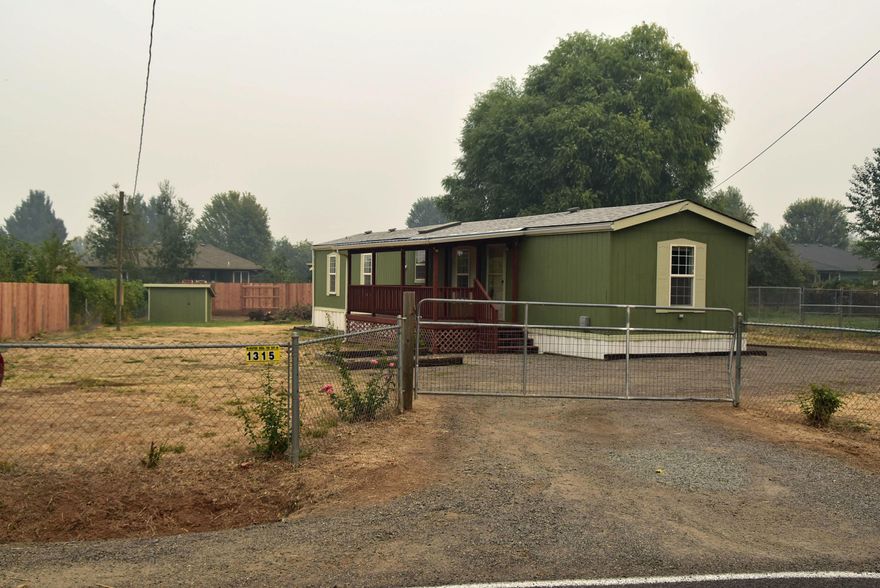 Wonderful Property! 2 Bedroom, 2 Bath home on Fenced/level  .38 ac Lot. New laminate wood style flooring, Refrigerator, Range/Oven and fresh interior paint. Spacious vaulted master bedroom with walk-in closet. Kitchen w/ Skylight. Living room w/vaulted ceiling. Front covered Deck and a Rear covered Deck w/ Carport. Plenty of yard for playing, gardening or RV/Toys. Location is close to all shopping!!