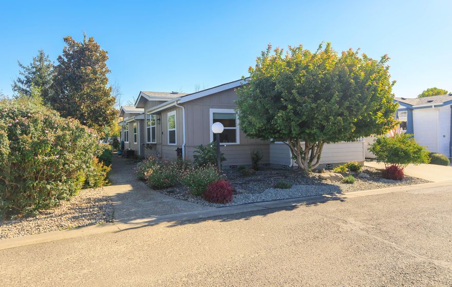 This beautifully maintained 3-bedroom, 2-bath 2003 manufactured home offers 1,625 sq ft of single-level living in the best spot in the park. The light-filled kitchen features a charming bay window breakfast nook, while the spacious living room boasts an architectural ceiling detail that enhances the natural light. Luxury vinyl plank flooring flows throughout the home, complemented by fresh interior & exterior paint. Since 2020, the owners have completely remodeled the front, side, & backyards, replaced all vinyl windows, interior lighting, & appliances, plus added a red cedar backyard deck & exterior fixtures. The primary suite includes a garden tub, separate shower, & walk-in closet. Enjoy the screened-in back patio with 4 new storm doors overlooking the landscaped, fenced yard along a peaceful creek. The park features a new clubhouse & pool, adding even more to this serene & social lifestyle. Move-in ready, stylish, & thoughtfully upgraded—this home blends comfort, function, & charm