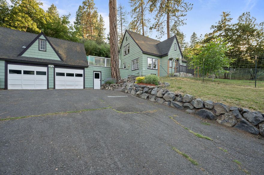 Appealing home with traditional design and numerous updates throughout. Open living/dining area with wood floors and beautiful stone fireplace with gas insert. The stunning kitchen has granite counters, 5-burner duel-fuel range with double ovens.  The spacious primary bedroom has vaulted ceilings and walk-in closet.  The on-suite bath has double sinks and jetted tub. Large, finished basement with full bath, built-in bar and ample room for all activities. Double car garage has enclosed breezeway from the house.  Above the garage, with separate entry is added living area for extended family, or a studio apt with small kitchenette and full bath. Currently the Sellers rent this through Airbnb for added income. Large front yard with patio and fenced area for pets/garden. Dog kennel and chicken house in back with a stairway path for hiking.  NEW SEPTIC TANK AND DRAINFIELD.  NEW GAS F/A FURNACE!