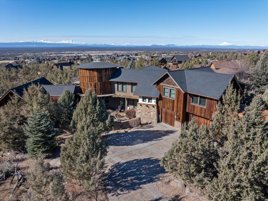 Iconic Custom Home w/ breathtaking panoramic Cascade Mtn views. Gorgeous natural landscaping surrounds this home to offer solitude and tranquility. Distinctive craftsmanship & quality of materials abound as you enter. In the open floorplan you will find, a vaulted great room w/ expansive stone fireplace, dining area, & prestigious kitchen boasting of counter space, stainless appliances, and a butler pantry. The spacious primary bedroom offers vaulted ceilings, rich beam work & a warm fireplace. The primary bath offers a well-situated soaking tub & large shower w/ dual vanities. An additional bdrm w/ deck access & a spacious laundry room complete the main floor. Upstairs, you will find another bdrm, full bath, family room w/ kitchen, an office, & an upper deck to enjoy the stunning Brasada sunsets. Downstairs is an impressive wine cellar, family room, a bdrm w/ full bath and access to outdoors. Outside, you will find an outdoor kitchen area complete with barbeque and stone fireplace.