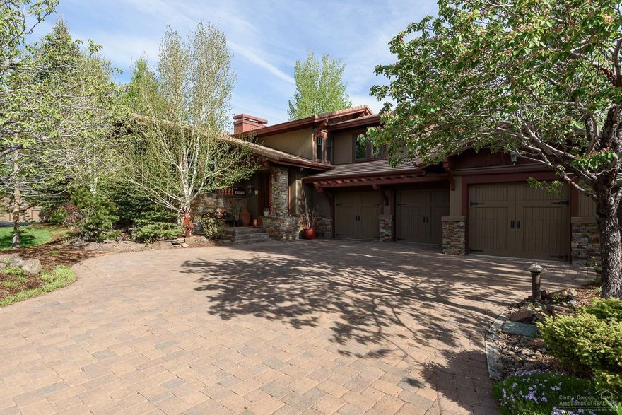 Custom Broken Top home located in private park-like setting on a quiet cul-de-sac. Fine craftsmanship throughout with dramatic high ceilings, exposed wood beams and grand double-sided stone fireplace. Mostly main level living with oversize master suite featuring stone surround fireplace, sitting area, patio access and large walk-in closet. Guest suite with large private bath and access to outdoor patio. Gourmet cook's dream kitchen with large island and breakfast nook. Second guest suite upstairs with built-in desk and shelving plus private full bath. Beautiful mature landscaped exterior with water feature and is located on a corner lot bordering open common area for additional space and privacy. Two private paver patios with a built-in BBQ along with a secluded court yard featuring a hot tub. Large three car garage with built-in cabinets. Large extra storage room next to utility room. Privacy, luxury and entertainer's delight.