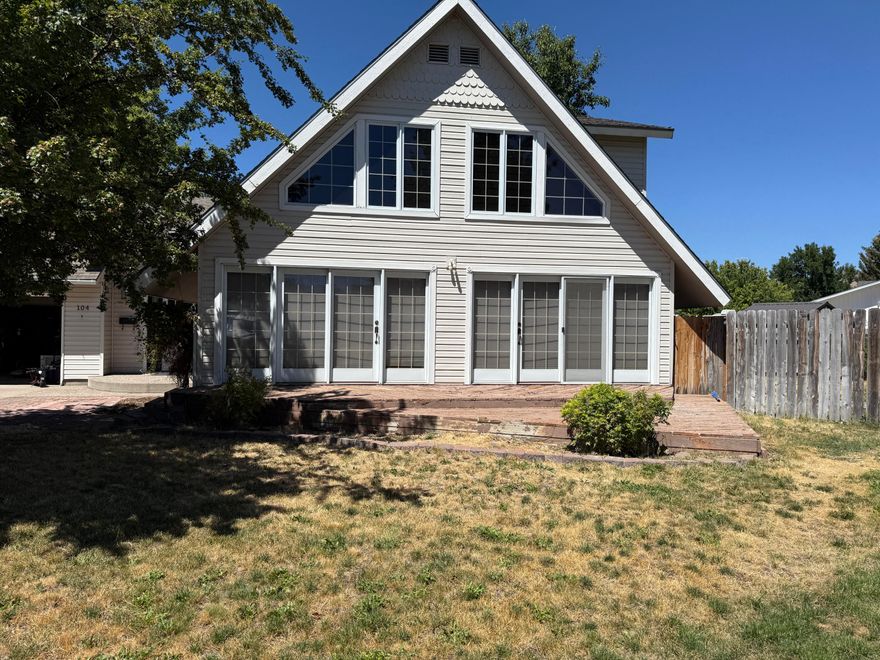 This beautiful custom 3-bedroom, 2-bath home offers natural light, soaring vaulted ceilings, and thoughtful design throughout. The main living area features two-story ceilings with decorative beams, nearly floor-to-ceiling windows framing mountain views, and dual doors opening to the front deck. The first-floor primary suite includes a private en suite, while upstairs a versatile loft provides more mountain views. Enjoy two living spaces: a family room with built-in office, pellet stove, and patio access, plus a formal dining room for gatherings. The kitchen boasts granite tile counters, Jenn-Air oven, breakfast bar, and built-in pantry. Energy-efficient updates include vinyl siding, double-pane windows, LED lighting, and insulated blinds. Outdoors, mature trees, low-maintenance landscaping, underground sprinklers with drip system, and a private fenced yard create a relaxing retreat