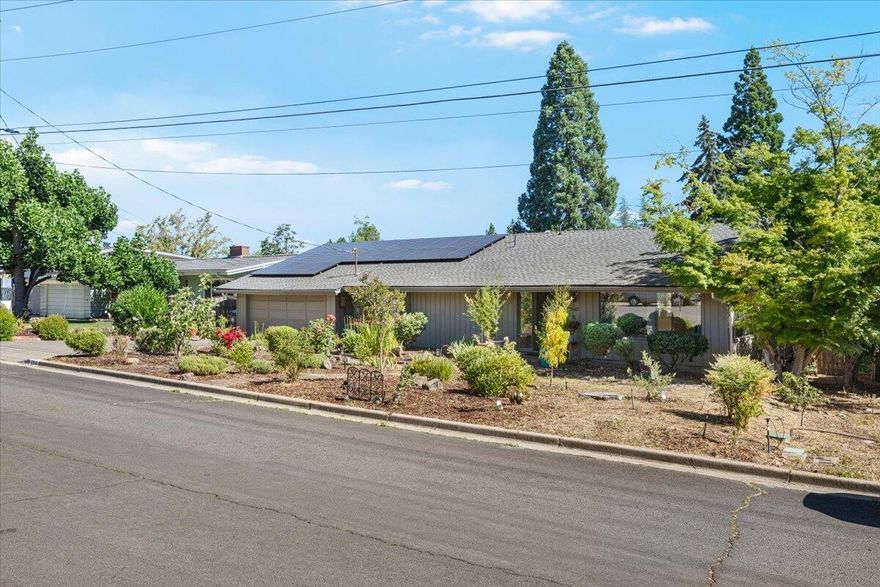 Beautifully updated 1,604 sq. ft. home on 0.27 acres in East Medford near Rogue Regional Medical Center. Energy-efficient with fully owned solar system! Offers 2 bedrooms plus a versatile bonus room—perfect for office, hobby space, or potential 3rd bedroom. The great room features hardwood floors, abundant natural light, and open living/dining. Cozy family room with vaulted ceilings, Jøtul stove, and views to the backyard. Kitchen includes granite counters, stainless appliances with gas range, and pantry. Both bathrooms offer heated floors, tiled showers, a soaking tub, and updated vanities. Enjoy easy access to the wraparound deck from four points—hot tub included! Deep backyard with mature trees, stone paths, and low-maintenance landscaping.