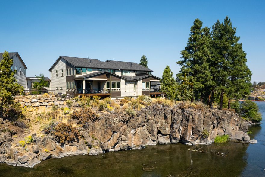 Rare opportunity to own a breathtaking townhome overlooking the Deschutes River.  Clean lines and luxurious finishes beacon you to pause and stay awhile. Upon entering you look through to the river views, covered porch with stairs down to the side yard sitting area, and outdoor BBQ kitchen. Vaulted great room, entertainers dream kitchen, and dining room flow beautifully to the covered deck and river. Spacious primary bedroom on the main floor with custom bath and door to deck. A huge laundry room leads to the garage that has added 220 outlets for Electric cars. From the entry past the office and half bath, you adventure upstairs under more custom Hubbardton Forge lighting to the loft area with the 2nd wet bar, 2nd bedroom suite, and 3rd bedroom. Private Access to the Deschutes River nearby for launching river fun! Head south on the Deschutes River Trail to downtown or head north to Sawyer Park and beyond. HOA takes care of exterior landscaping, building maintenance & snow removal.