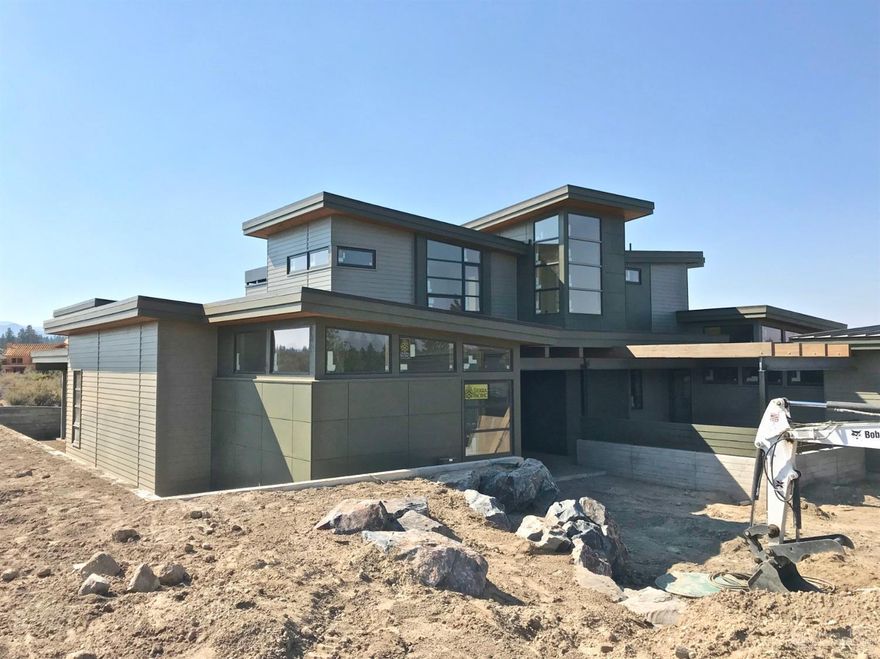 From the chef's kitchen to the voluminous great room with accordion glass doors opening to covered terrace with outdoor kitchen to the rare 4-car garage, this thoughtfully-designed contemporary home with sweeping Cascade views exemplifies Bend Trend's industry leading style. Master wing boasts private den and spa-like bath with heated floors and private patio with screened hot tub. Upstairs incorporates a third suite, bonus room, fourth bedroom and bath. This home embodies Tetherow living at its finest.