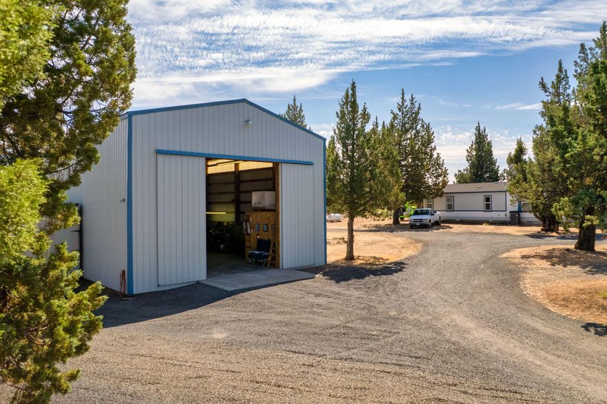 First time on the market! Are you looking for acreage, a well maintained home with a user-friendly backyard garden space, and a huge do-it-all shop? At just under 6 acres, this 1400+ square foot 3 bed, 2 bath manufactured home is ready for new owners. Owners have taken meticulous care and paid close attention over the years, being good stewards to this home and land. The shop, at 1800 sq. ft., has 18-ft high trusses and a 16-ft French slider, office/storage rooms and additional mezzanine storage, with a rollup door on the back wall, will make other shops jealous. The wood fence, with a greenhouse bump out, surrounds a lush backyard replete with flower and garden beds, a small lawn all looked after with an adaptable watering system offering the green-thumb-inclined person a satisfying oasis. All of this, just down the road from Steelhead Falls in Crooked River Ranch, where community & recreation meet between the splendor of the Deschutes and Crooked River canyons.