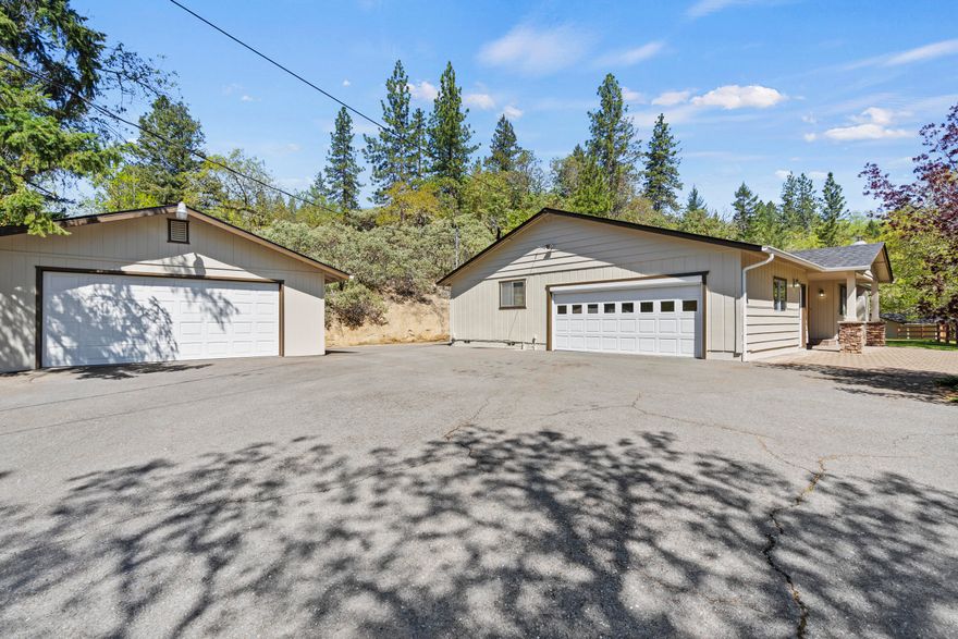 Luxurious living awaits in this meticulously appointed home on 2.5 acres! Enjoy the elegance of Corian kitchen counters, ample storage including a pantry, and instant hot water at the kitchen sink. Bedrooms are nice sized and all bedroom closets are back wall lined with cedar! LED lighting illuminates the attached 2-car garage with its race deck flooring, while a roll-up screen adds versatility. Additional detached finished and insulated 2-car garage. Outdoor living is a breeze with a Trex decking patio, automatic SunSetter awning, and a 3 rail vinyl fence for privacy. Stay comfortable year-round with a thermostat-controlled heater in the garage and a full-house Generac generator. Plus, Leif gutter guards, new 30 year roofs, and some fresh exterior and interior paint add to the allure of this exceptional property. Call your Realtor today to tour this wonderful home that's only about 10 minutes to downtown Grants Pass.
