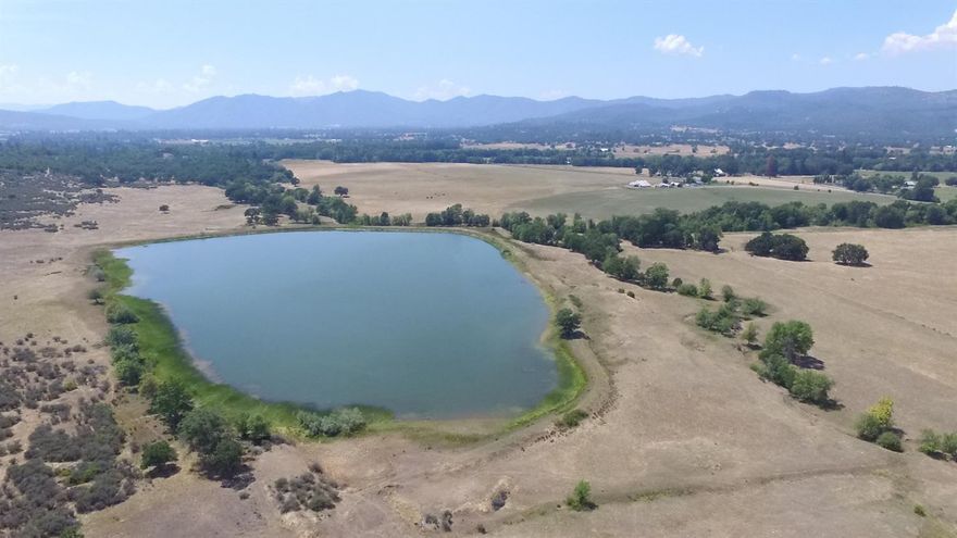 205+/- acre farm. Approximately 145 productive, tillable acres with soils that could be classified as organic. Currently in hay production and cattle grazing. Over 50 acres of water rights and initial investigation suggests that more may be available. There are two pivots, one full and one half circle. The 2077 square foot single level home has been tastefully updated and has 3 bedrooms and 2 1/2 baths and features vaulted ceilings. The hay barn is 80X120 with stalls and turnouts. The equipment building is approx. 80X28 and the secondary equipment shed is approx. 60X20. The property is served with 3-phase power. The reservoir covers 12+/- acres and Snyder Creek runs through the property. Plenty of wildlife visit the ranch including deer and elk and it borders BLM land and Upper Table Rock.