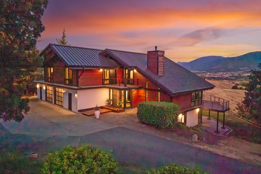 A private retreat setting where nature meets luxurious living. The 5BR/5BA Contemporary home  captures the Siskiyou mtn range at every turn. The main level offers floor to ceiling windows, hardwood floors, living & dining room & Chef's kitchen appointed w/ island, wet bar, pantry, double ovens, wolf stove & more! Upstairs the main bedroom suite is an oasis unto itself w/views, decking & spa. A second primary suite, 2 add'l  bedrooms/bath & laundry room w/abundant storage are downstairs. 
Each room has custom finishes & exquisite views to ensure a lifestyle of privacy &  relaxation. Outside you're met w/soothing soundscape of a tiered cascading creek, lagoon waterfall style pool, cabana area, outdoor kitchen & bath, for ease of entertaining. Equestrian, livestock or agricultural enthusiasts will delight w/the endless possibilities. Fruit trees, garden beds, greenhouses, chicken coop & workout room complete this singular estate. 1BD/1BA guest apartment is a bonus to this luxe property.