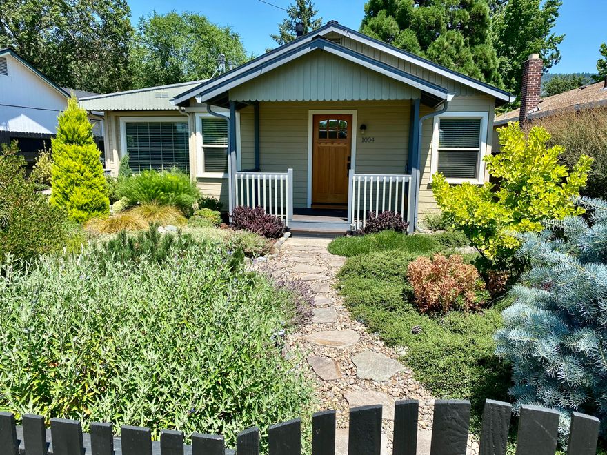 Absolutely charming country cottage in pleasant NW Grants Pass neighborhood.  This sparkling 2 bdrm (per assessor--one being used as den) home makeover has an amazing kitchen, clear fir floors, vinyl windows, ductless heating/cooling system, vintage gas stove in LR, and super efficient use of space throughout.  Kitchen features gas stove, stainless appliances, and seeded glass front custom cabinets.
Cozy front porch overlooks beautiful landscaping featuring stone walkways, arched footbridge, and incredible plantings.   Backyard has stone patio, attached deck, and a garden of eden in landscaping.
Detached single garage with small shop.  With Pride of ownership everywhere you look, this absolutely turnkey home is truly remarkable!  All information is deemed reliable but not verified; anyone considering purchasing this property should perform their own investigation into the uses and condition of the property.