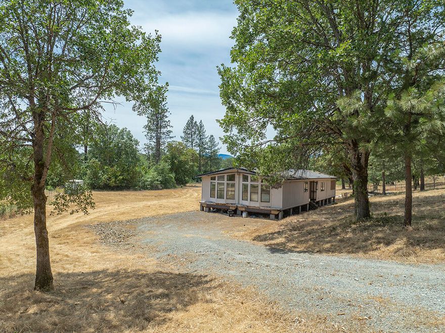 Peaceful Country Retreat on Usable Acreage Close to Town! Welcome to 5478 Monument Drive, where rural charm meets everyday convenience. This diamond in the rough sits on a level and usable 2.4-acre parcel in the desirable Merlin area. The two-bedroom, two-bathroom manufactured home offers an open, functional floor plan and is ready for your personal touch and updates. The expansive outdoor space is ideal for gardening, animals, or building your dream setup, with plenty of room to expand or customize. OWNER WILL CARRY. Experience the beauty and flexibility of country living, just a short drive to Merlin, downtown Grants Pass, schools, and local amenities. Buyer to perform their due diligence.
