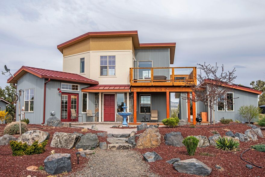 838 SF home boasts high ceilings and views from every room. There are a separate 200 SF studio and 180 SF office/utility room. The kitchen/living room is upstairs with 2 bedrooms and bathroom down. 360 degree views include the Three Sisters, Mt Bachelor, Mt Washington, Black Butte, Powell Butte, Horse Butte and Bend City lights. Off grid power supplied by 8 solar panels (2.1 kw system) with a generator for back up (new  batteries April 2021). The on demand water heater and passive solar provide added efficiency. 2 X 2500 gallon  and 1 X 2000 gallon above ground cisterns) and a 250 gallon propane tank. Standard septic system with 1000 gallon concrete tank and 225' of drain line 7/8 corrugated metal, HardiePanel and natural rock siding provide beauty and durability. All buildings are 2'' x 6'' construction with plywood (no OSB) and fully insulated.  Roofing is Taylor VersaSpan. Paver patio and xeriscaping create an outdoor oasis.