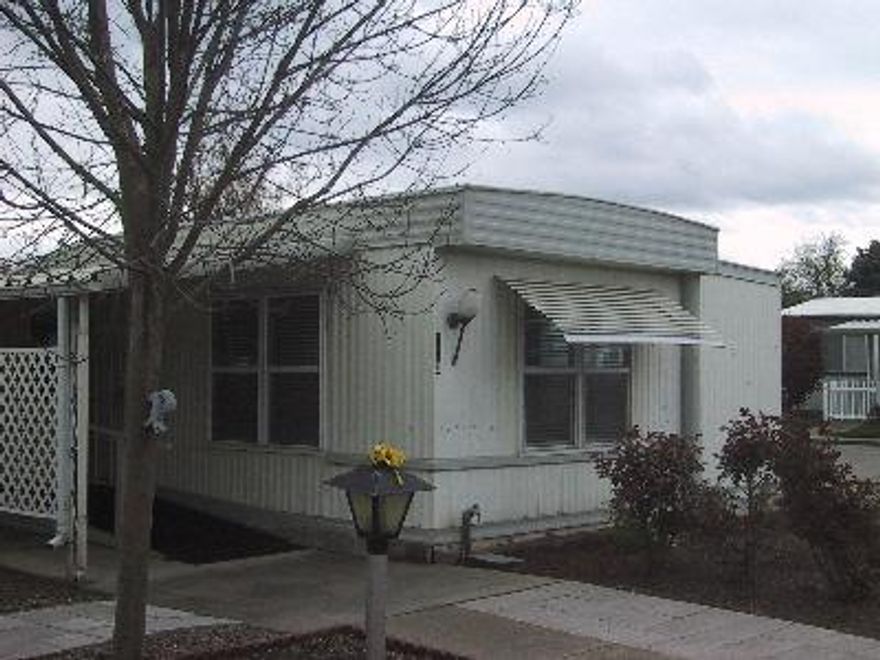 Pride of ownership and sparkling clean throughout, light, bright, vacant, and ready to move into! The pop out in the living room creates an open feel. Nice carpet and vinyl, new blinds in living room, double-pane windows, new oven/range, kitchen sink and Maytag refrigerator, stackable Maytag washer and dryer, new shower surround, built in desk and drawers plus 2 closets in bedroom. Three exterior storage sheds, nice covered patio and easy care landscaping. 55 and older park. Space rent is $312.00.
