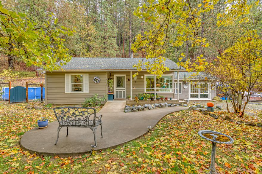 Experience the changing seasons and birds playing in front of this charming rural Southern Oregon home through the huge picture windows. In addition to the two-bedroom cottage, there is a converted garage with lots of storage and great lighting that could be used as an extra bedroom, music room, playroom etc. Summit your own mountain on the back of these 11+ acres or use front couple of acres for room to expand the garden, keep animals, or simply let the wildlife roam. Recent upgrades include a new well pump and a new roof, providing peace of mind alongside a clean inspection report. Inside, the home features timeless oak hardwood floors, an upgraded kitchen with stone counters and stainless-steel appliances, and at its heart, a Blaze King fireplace. This property is move-in ready. Come enjoy this slice of Southern Oregon Heaven for yourself.