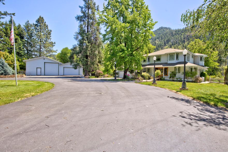 River paradise with magnificent Rogue River frontage, heated pool, & private lake. This estate-like setting on a level 11.14 acres with tree-lined entrance, includes a beautiful 3-bedroom 3 bath home, 2-car garage, 1040 sq ft workshop/garage, detached 720 sq ft garage & RV parking with hook-ups. The home is rich with charm & perfectly suited for this amazing setting. The main level includes a spacious gourmet kitchen open to the family room with fireplace, a temperature-controlled wine room, living room, full bath, & large bedroom. The main floor takes advantage of the river view with walls of windows & French doors accessing a large, covered patio with BBQ plumbed for natural gas. The upper level with master suite has a private deck facing the river, a third bedroom, and office which could be converted to another bedroom. Location is perfect for fishing, kayaking, swimming & outdoor entertaining. Includes First American Eagle Premier Home Warranty. Property has river irrigation rights