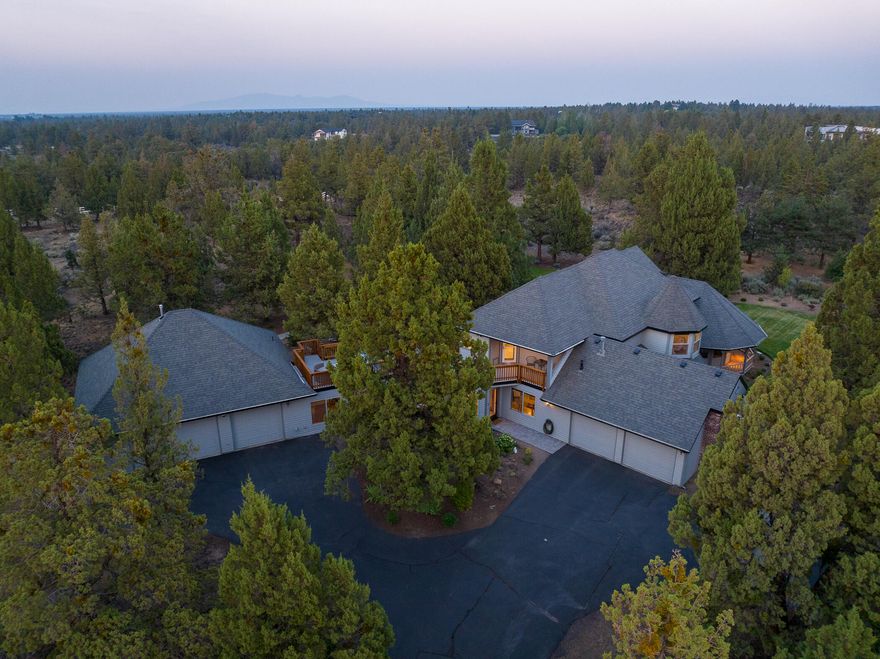 Enjoy the peaceful and private setting on this small acreage sweet neighborhood, just minutes from shopping and restaurants at the north end of Bend. Beautifully landscaped and peek a boo mountain views make this property a lovely place to call home. Many custom features including wide plank hardwood floors, radiant floor heat in kitchen and primary bath, cherry cabinets, solid granite countertops, stainless steel high end kitchen appliances (most are Miele brand), wet bar, very spacious primary suite with a large sitting area, soaking tub, and steam shower, closet system in all bedrooms. 2 oversized garages (32x36 heated shop/garage with sink, 220 power, and electric car charging station).  Open floor plan with plenty of room to entertain both inside and out. It's a must see! Take a look at the photos and descriptions and make an appointment to see this stunning county property so close to town!