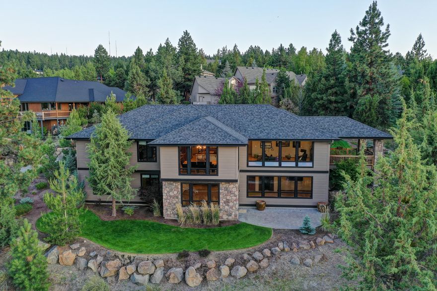 Exquisite Northwest contemporary with mountain and sunset views, exceptional privacy and incredible indoor spaces. The perfect home to shelter in place, work, study, exercise, relax ALL year long! Built in 2015 this stunner has an enormous dining room & kitchen built for chef's. See forever views from expansive windows lining great room. Reclaimed barn wood accents, refinished Hickory wood floors and a covered deck just add to the allure. Main floor feels like single level living with a beautiful primary bedroom suite, XL guest room, huge office with built in Murphy bed, shelving, credenza and desks & laundry room off 3 car garage. 
Light, bright downstairs w/high ceilings, a 2nd kitchen/bar that opens out to living/game room. Fully equipped in-home theater with 9 leather recliners, Kliptsch speakers, surround sound and 12' screen! Lower level has: two more bedrooms, hobby room, full bathroom and loads of storage + door out to paver patio and yard. Nothing else like it on market!