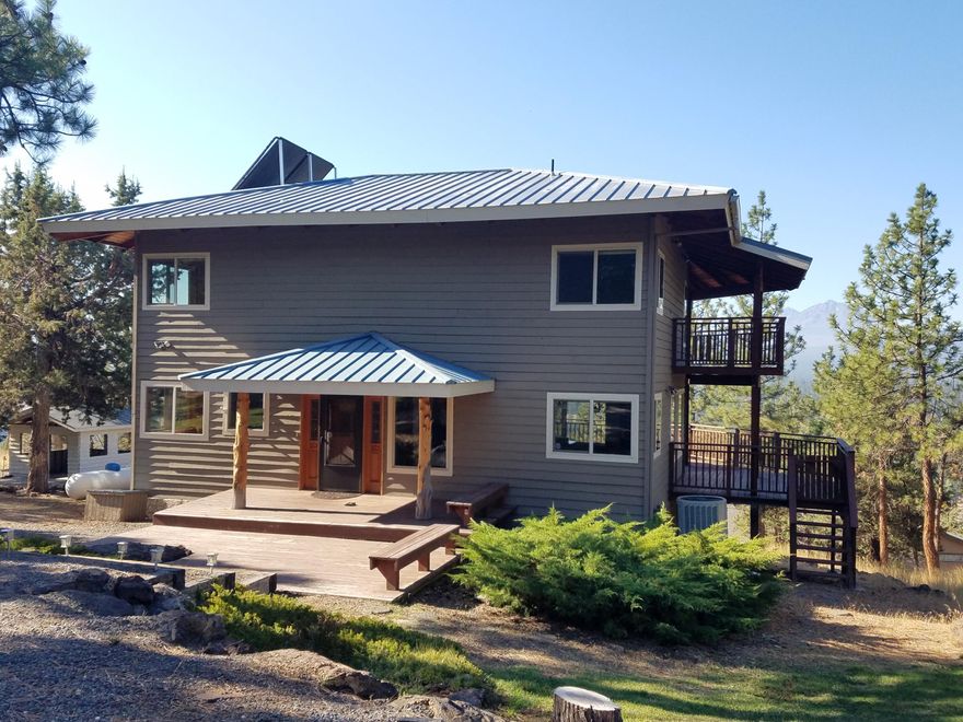 On Top of McKinney Butte... Overlooking the Cascade Mountains and Sisters, the town of tiny lights. This property has a combination of special features not often found. The main house has a rustic, yet modern interior filled with knotty pine and accented by Juniper logs. Exciting 3-level floor plan with high vaulted ceilings and spaces filled with windows providing natural light and Cascade views from most rooms. The 9.9 acre rural lot features comfortable detached guest accommodations with garage and a long term cell site camouflaged into the charming architecture. End of the road privacy - Forested with ample sunlight - Dramatic setting with Cascade views - Private guest accommodations - Income stream - What more could you want!