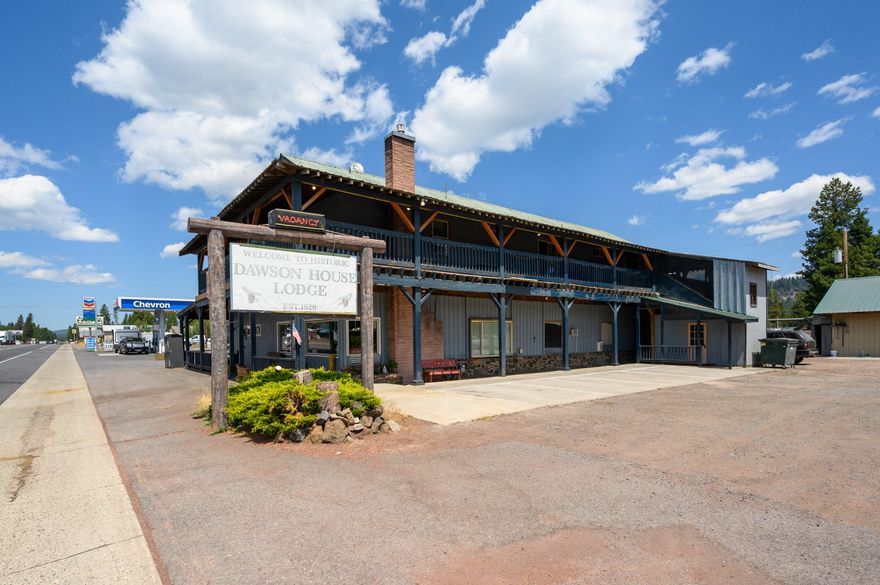 The Historic Dawson House Lodge was built in 1929 to serve the new Hwy 97 travelers & serve as a boarding house for railroad & highway workers. Since that time, the building has been highly upgraded/renovated & features 9 rooms, all with their own bathrooms. The largest of the suites has a full kitchenette as well. Every room has outside access to the covered deck, great to shield from the snow & bright sunshine. The building has natural gas & 400 amps of power, more than enough for current demands. Parking is excellent w/room for over 30 vehicles & several tractor trailers. On the main level travelers are greeted by a cozy lobby w/seating, coffee, a fireplace, & high-speed internet. The entire property is served by Starlink & each room has a TV, fridge, & microwave. The owner's quarters are generous & in good condition. The shop outside has lots of utility, 2 12' roll up doors & a heated rec area w/linens storage. Only 30 minutes from Crater Lake & the opportunities are endless.