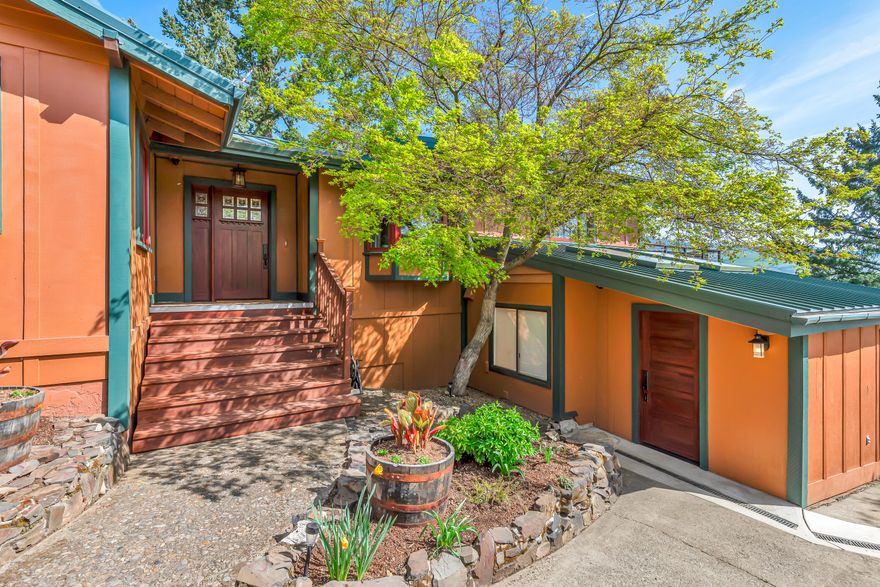 Updated view home above the boulevard near Asante Ashland Community Hospital, just four minutes from the plaza and Lithia Park! Tiled entry and formal dining with two wine refrigerators and built-in buffet, gourmet kitchen with radiant heated floor, stainless appliances including two Wolf ovens, six-burner cooktop with griddle, two dishwashers, and pantry with second refrigerator. Vaulted great room with exposed beams, river rock fireplace with wood mantle, and sliding glass door to refinished redwood deck with panoramic mountains and valley views. Three main-level bedrooms and two full bathrooms including primary with walk-in closet and full ensuite bath with radiant-heated floor, double vanity, and tiled shower. Lower level with new carpet in fourth bedroom or office and spacious family media room, half-bath, gym with washer dryer hookups, plus a 300+ SqFt bonus room with two skylights suitable for workshop or potential guest quarters with exterior entrance. Inquire for details!