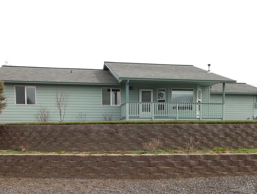 Move In Ready - Super nice frame built home with new carpet, vinyl flooring, paint inside and out, pellet stove, 3 yr old range, microwave and dishwasher on a fully fenced and cross fenced acre with gates to allow ease of parking and moving trailers and RV's. Enjoy nice sunsets from the covered front porch and some mountain views. Attached double car garage with a generator hookup. Located on a paved road.