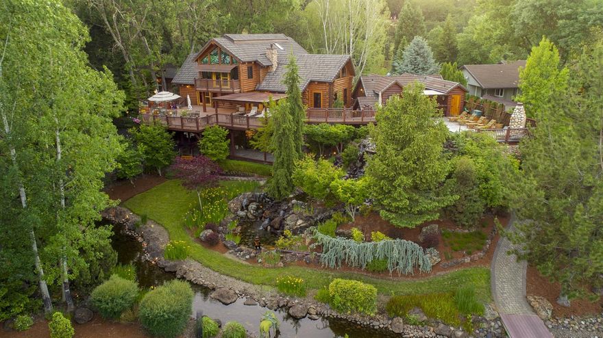 AUCTION: Bid July 11-15. Previously $1.95M. Without Reserve. Open Daily 1-4PM By Appointment. Enter through the gate and into a lush forested escape with meandering paths, waterfalls, and a riverfront view. A luxurious log cabin compound of four structures connected by an extensive outdoor entertaining deck, Maison Stonewood waits to welcome you and your guests to the Pacific Northwest. Take a swim overlooking the Cascades, serve cocktails from your cabana bar, venture out on the river for rafting or fishing, or simply curl up in front of the outdoor fireplace as cool evenings envelop you. Whether you aim to create the ultimate family vacation estate, a deluxe B&B or a retreat oasis, this incredible property on 2.5 acres sits ready to provide the backdrop for your personal or commercial vision.