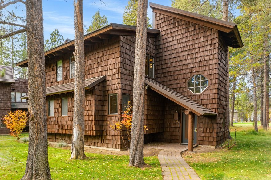 Location is everything! Lovingly owned by the same family for generations, this special retreat is ready to be passed on to the next owner. #12 Wildflower offers the ultimate Sunriver experience—just moments from the Village & Sunriver Resort, with panoramic views of the Meadows Golf Course. This charming three-level lodge-style condo features 2 bdrms, 2 baths, & two stunning wood-burning stone fireplaces—one in the great room & another in the primary suite. The ground-level entry provides convenient storage. The mid-level hosts the primary suite with a private balcony overlooking the greens, plus a guest bedroom & adjacent full bath. The top floor showcases a great room, open kitchen & dining area that flow onto a view deck surrounded by pines and fairway vistas. Don't miss the rooftop getaway—an ideal perch for stargazing or soaking in the beauty. Recent updates include quartz countertops in the kitchen & baths & refreshed showers. Sold furnished, A/C and an established rental.