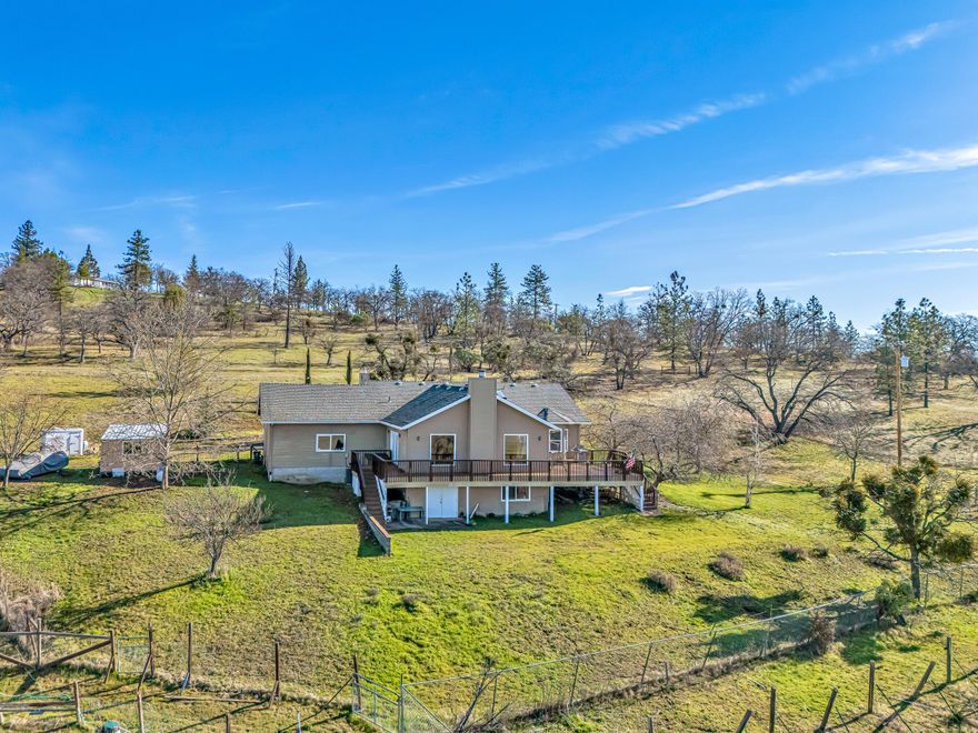 A working 10-acre farm featuring a 2,218 sqft home built in 1993, with 3 bedrooms and 2 baths, plus a finished basement. The home boasts a formal living room with a gas fireplace, kitchen equipped with gas cooktop, double ovens, breakfast bar, pantry, granite countertops, and stainless-steel appliances. The great room includes a wood-burning fireplace and abundant natural light, offering stunning valley views. The ceilings throughout are 9 ft high. There is a spacious deck ideal for entertaining and enjoying the spectacular views of the Table Rocks and Siskiyou mountains. An oversized finished garage was designed to accommodate a potential second story, which was never constructed, and provides ample storage, including usable attic space. The basement area contains two bonus rooms, each measuring 12'x 24'. The property is fenced and cross-fenced into 10 sections, includes a 30'x60' barn for animals, additional outbuildings in pastures, and a half-acre fenced vineyard.