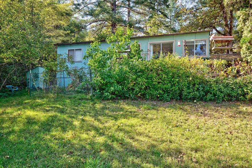 In the calm Illinois Valley sits Hodge Podge Lodge! Set in the lush greens, built around 2002, 1 bedroom, 1 bath, 576 sq. ft. rustic bungalow. An enclosed glass entry welcomes you in. Living room has open beam ceilings, wood stove and door to side yard. Two steps up takes you to the Main bathroom and master bedroom with unfinished ceilings open sliding glass door where the creek dances by. Kitchen is adorable! Dining area has slider out to deck with front lawn and mountain views! There is a carport and a storage/garden shed. Apple, peach and Cherry trees line the driveway. Irrigation rights from creek go with property. Property is completely fenced and gated 2.26 acres. Cash Only. No Owner Carry.