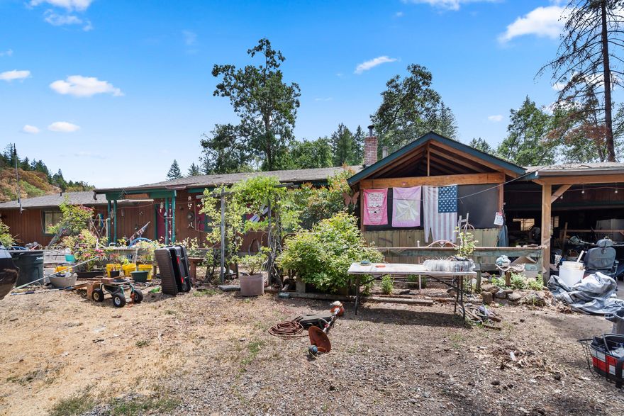 Incredible opportunity! Two parcels totaling 23 acres just minutes from Cave Junction. The main 5-acre lot features a 1,848 sq ft single-level home with vaulted, beamed ceilings, wood flooring, and a fireplace for cozy evenings. The spacious kitchen includes a skylight, generous storage, and flows into the dining area with wood floors and sliders to a 425 sq ft deck. The primary bedroom offers two private bathrooms—one with a tiled walk-in shower, the other with a soaking tub—and a walk-in closet. There's also a second bedroom, a third room for office or bedroom use, plus a guest bath. Outside: 4-car garage, carport, enclosed porch, and plenty of open space. The second parcel provides 18 private acres with Forest Commercial zoning—ideal for forestry, recreation, or possible development. Enjoy rural living close to dining, shopping, and hiking trails. Live, work, or invest—this versatile property has it all!