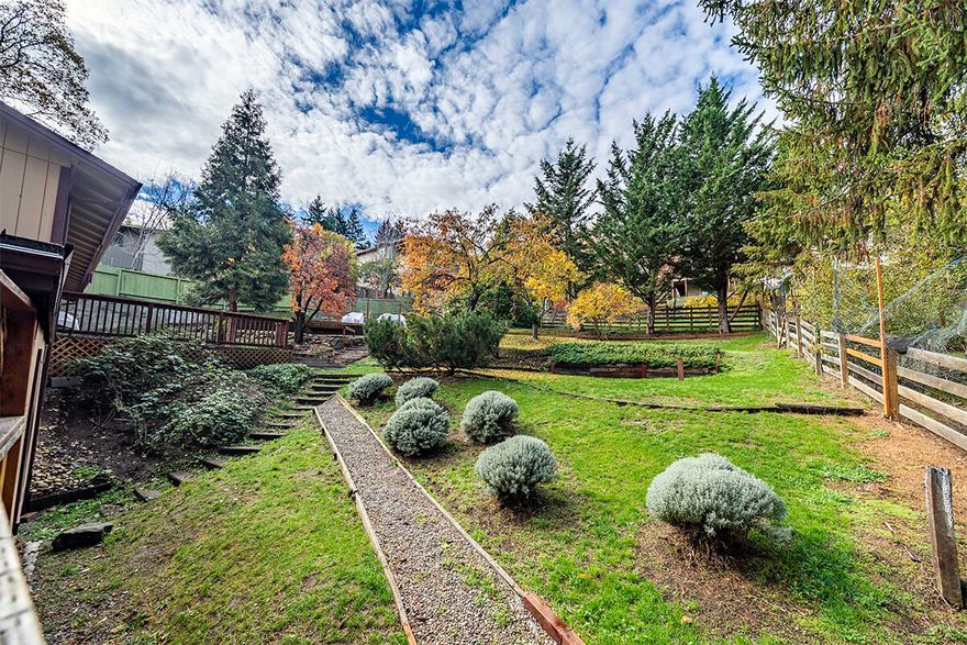 Immaculate & bright well-loved home with extra living for extended family & gorgeous mountain views. Very large .29 acre lot with large decking, garden, mature trees & lawn areas make this a very special property. Open concept living with wonderful natural light & gleaming quality laminate flooring in the main living areas. Spacious living room with views, updated kitchen with tile flooring, great counter space, tile, backsplash, stainless appliances & gas range, opens to the lovely dining room with access to large outdoor entertaining deck. There are 3 main level bedrooms & nice bath with pedestal sink & shower/bath combo. Well thought out lower-level features fully contained unit for extended family is accessed from within the home or by the separate entrance. This space includes view bedroom, nice sized bath & large kitchen with dining area (no stove), laundry area & separate entrance. Many different outdoor living spaces & gardens will inspire your life. Great exterior storage.