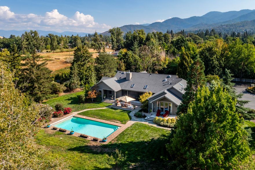 Rare single-level view home on private acreage in a desirable close-in neighborhood of high-end country estates. Abundant natural light and air flow with operable casement windows and NanaWall glass doors, exceptional outdoor living areas with custom lighting, remote-operated screens, heated in-ground saline pool, and cabana area with gas fireplace. Gourmet kitchen with walnut island and granite dining counter, stainless Wolf convection ovens, and six-burner Dakor gas cooktop. Temperature-controlled walk-in pantry and 600+ bottle wine cellar. Primary suite with spacious walk-in closet and full ensuite bath with double vanity, radiant-heated tile floor, and curbless shower. Media room or potential second primary with walk-in closet, full guest bath, guest bedroom with closets, office or third bedroom, laundry room, and attached two-car garage. Mature trees, ornamental plantings, water features, fenced organic raised beds, and barn with RV parking and half-bath. Inquire for details!