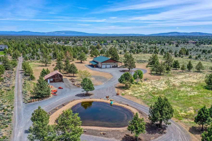 HUGE PRICE IMPROVEMENT!!! SHOPDOMINIUM on 19.84 Acre Parcel just outside Bends UGB.  7 acres of Irrigation fed by a lined pond, mix of Inground & K-Line Pod Irrigation recently installed. Includes an adorable 1384 SF attached home. This home has all the upgrades! Wooden ceiling beams to its radiant floor heating for consistent cozy temperatures. There is attention to detail everywhere with simulated wood-looking tiles throughout, spacious primary bedroom including walk-in closet and lots of built ins, dedicated office (or second sleeping area) with French doors, and a kitchen that boasts soft close knotty alder cabinets, Dekton solid surfaces, extensive storage and Stainless Frigidaire Pro appliances.  Make yourself at home here, and then spread out into the spectacular Shop area.  This complete Shop lover's paradise is roughly 60 ft X 40 ft with 2-12 ft X 14 ft doors, and additional 1632 SF upstairs space, sink & cabinet area, full bathroom, & 12 ft. X 40 ft. covered overhang.