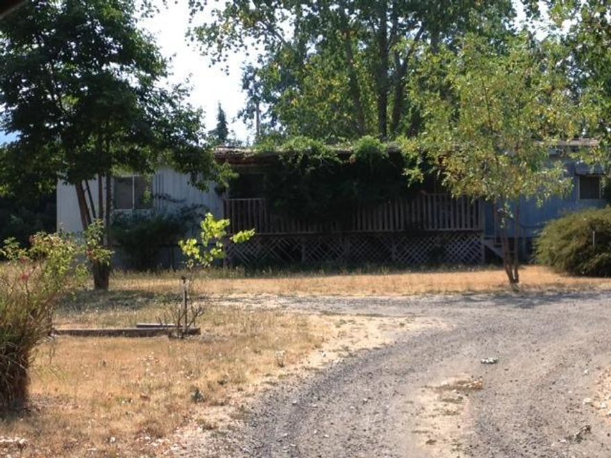 Level one acre rural parcel off Camp Baker Rd. in Phoenix. Currently has an older manufactured home on it that is not owned by the sellers but the owners are paying $300 a month to lease the land. The new owner can continue to rent to them or they would need 6 months notice to get the home moved off the lot. Owner would carry with 25% down, terms to be negotiated. Could be purchased with adjacent lot for two full acres, see MLS #2938639 Nice, close in country setting.