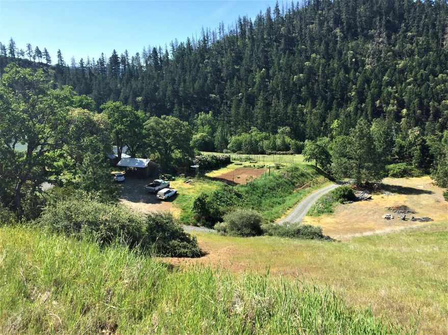Looking for privacy, year round ponds, open pasture, timber and super cute historic home with lots of detached living spaces on 220 acres, here it is! Best of all only minutes from Ruch, the Applegate Wine Trail & Historic Jacksonville. There are 4 year round spring fed ponds, one is called the swimming pond, almost an ac in size has a covered deck and zip line. The upper pond has views of snow-capped Red Butte Wilderness. This property has irrigation rights from the ponds for watering over 13 ac of pasture. The main house is close to 1000 sq ft, been remodeled in 2010. The nearby shop has 2 bedrooms a large kitchen and living room updated in 2017. There is another living space that is a high end Travel Trailer with its own screened in porch for comfortable summer sleeping. All powered by high end solar array. The barn over 3000 sq ft could easily be turned into a horse barn. There is an established orchard and large vegie garden. Surrounded by BLM and plenty of trails to hike or ride