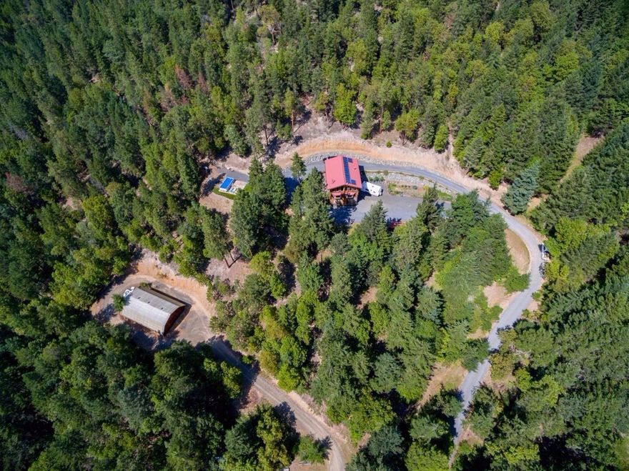 Price Reduced to Sell! Beautiful Log home with end of road Privacy. Potential Grow in approx 1500sf Greenhouse. Southwest facing sunshine above fog line. Zoned FR. BLM on 2 sides. Has it all! Minutes to charming Jacksonville. Open lodge style 2200sf Log home built 3 stories to encompass the view via large trapezoid & bay windows. Has 2br/3ba. Loft has bedroom, office, walk-in closet, master bath w/jacuzzi tub & bay windows. Spacious kitchen w/custom cabinets, propane jenn air range & comfortable work triangle. Daylight basement w/bedroom, laundry room, full bath, 1 car garage(convert to rec room, or bdrms w/buyer due diligence to county). 79.6 acres with merchantable timber. Roads/trails on property & BLM for hiking, riding & recreation. 14 solar panels to augment power. Newer dual fuel heat pump. 2 major out buildings, power & water accessible. Approx 1500sf greenhouse/shop & approx 1600sf utility bldg for shop/storage/or? Appt Only. No Drive bys!