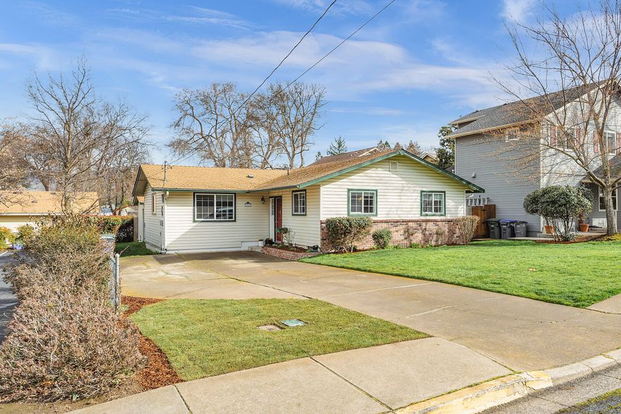 Beautiful, spacious yard and newer deck, perfect for entertaining guests at a summer cookout.  Fenced-in backyard with cute garden shed.  Separate bonus space, currently being used as a music room with skylight.  Kitchen features crisp white cabinetry, and quartz counter tops.  Striking hardwood floors throughout, except 2 bedrooms.  Wood burning fireplace in primary bedroom, perfect for cozy winter nights.  Property backs to alley with access.  Convenient location to SOU, High School, Middle School, Elementary School, and Restaurants.